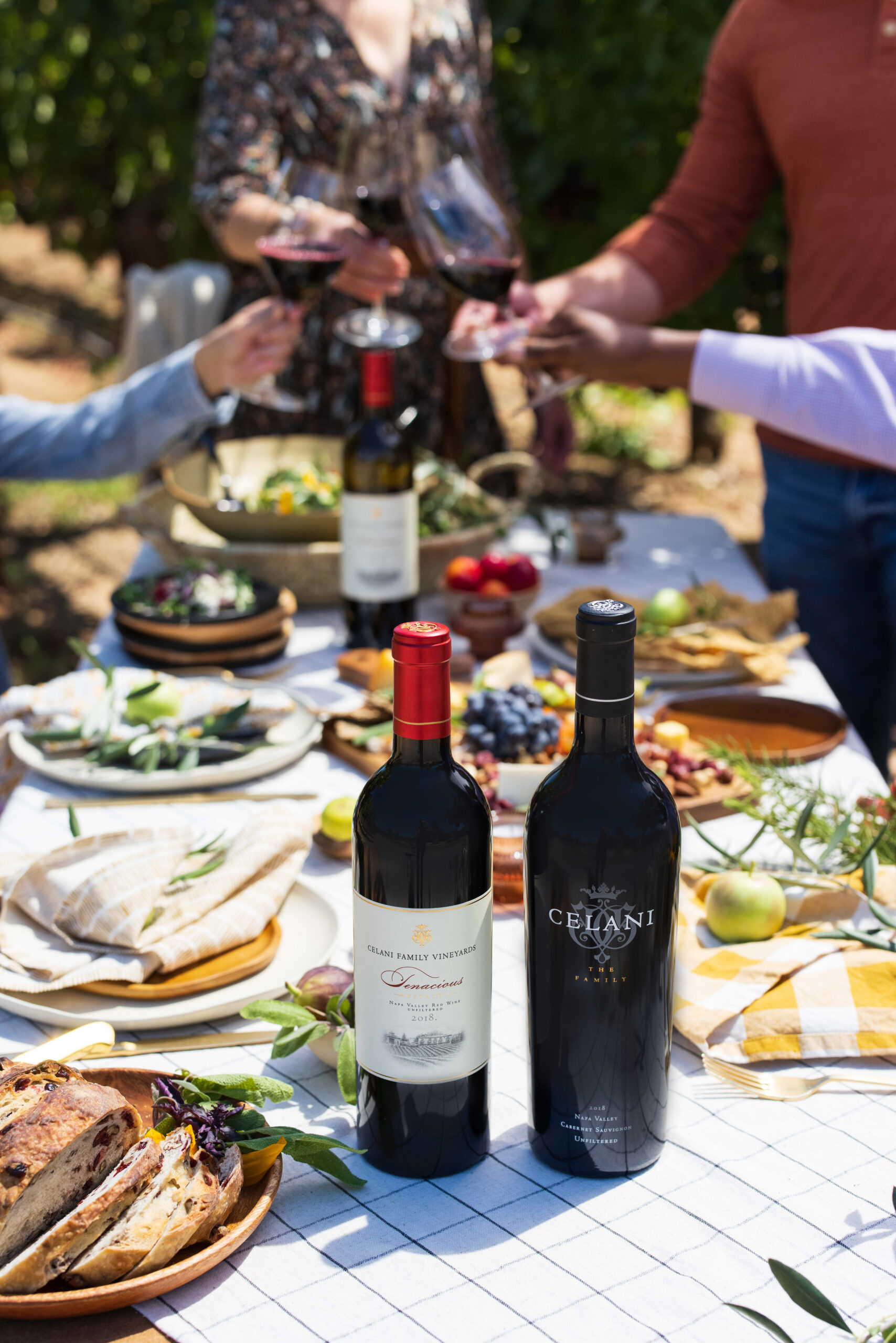 A wine tasting table set with Celani Family Vineyards bottles and a spread of food